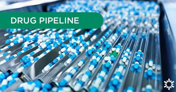 Drug Pipeline – Blue pills traveling through a sorting machine, a green pill stands out from the rest.
