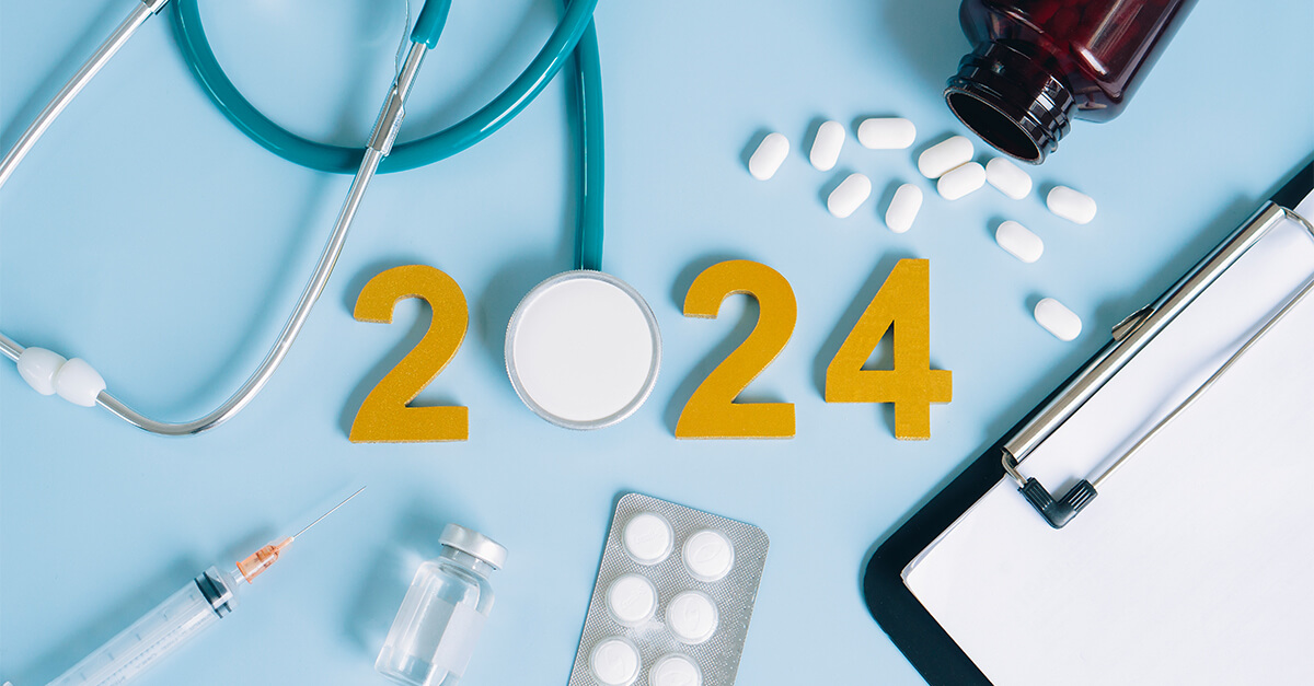 Looking down at a counter with scattered medications and a stethoscope as the "0" in the word 2024.