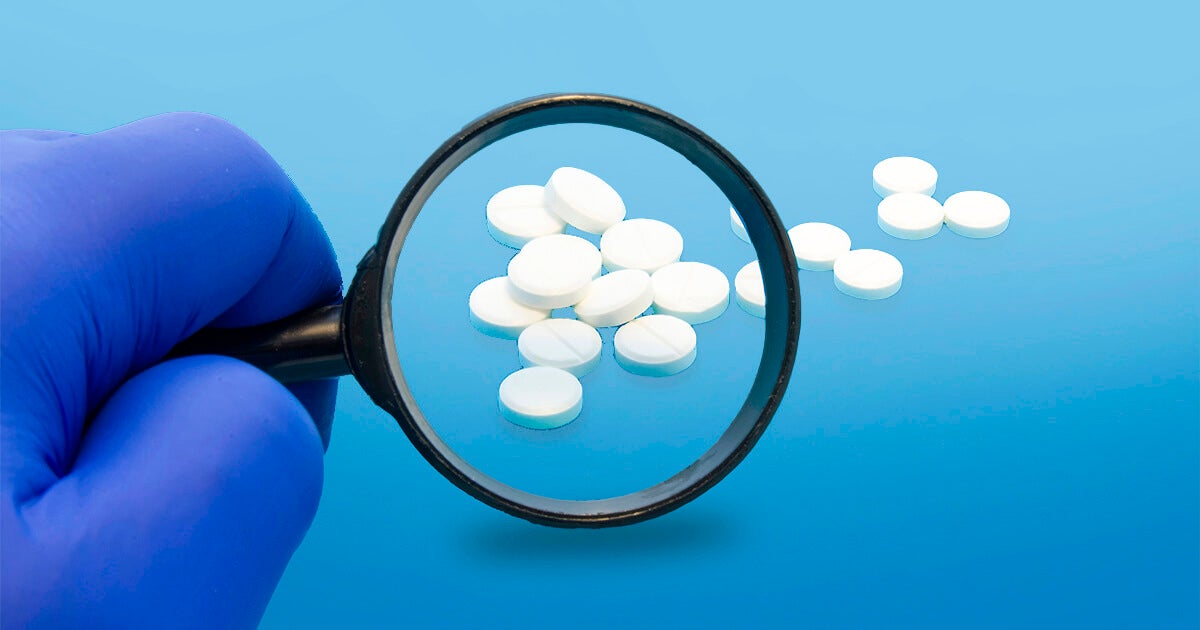 Magnifying glass looking a pills